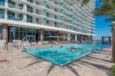 a swimming pool in front of a hotel at Ocean View Balcony with Pool Gym Access in Hallandale Beach