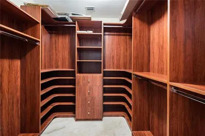 a walk in closet with wooden cabinets and shelves at 2/2 Boutique Condo in Ft. Lauderdale in Fort Lauderdale