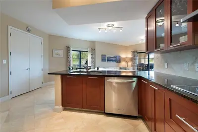 a large kitchen with wooden cabinets and stainless steel appliances at 2/2 Boutique Condo in Ft. Lauderdale in Fort Lauderdale