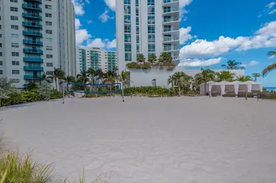 a large white beach in front of buildings at 18th Floor Ocean Views Pool Beach Fitness in Hallandale Beach