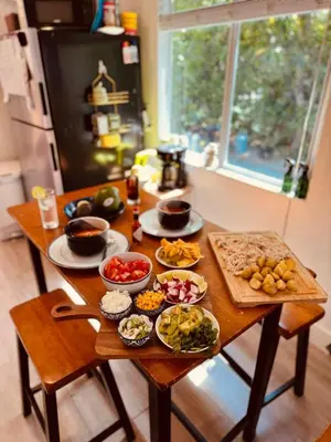 a table with plates of food on it in a kitchen at Quiet & Centrally located House - PRIVATE PARKING, LAUNDRY AND STORAGE FOR LUGGAGE in Miami