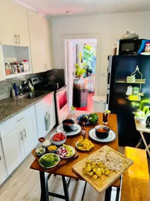 a kitchen with a table with plates of food on it at Quiet & Centrally located House - PRIVATE PARKING, LAUNDRY AND STORAGE FOR LUGGAGE in Miami