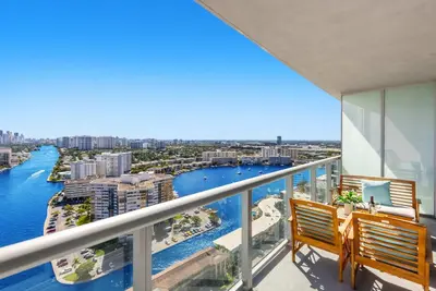 a balcony with two chairs and a view of the water at Near Beach - Pool - Infinity View - Balcony - Gym in Hallandale Beach