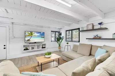 a living room with a couch and a tv on a wall at Sun Getaway Rentals in Fort Lauderdale