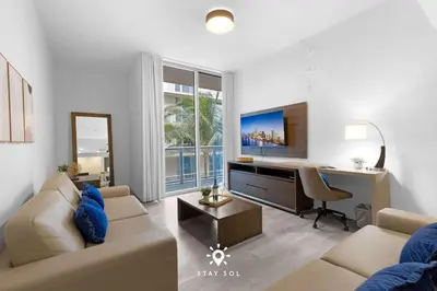 a living room with a couch and a desk at Amazing Pool - Hot Tub - Hollywood Beach Haven in Hollywood