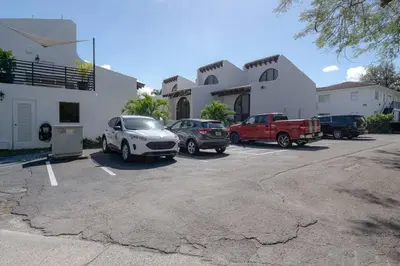 a parking lot with cars parked in front of a building at Villa at St James Unit A Luxury Pool Villa, Pet Friendly in Miami