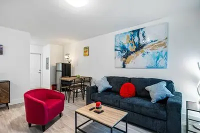 a living room with a blue couch and a red chair at Huge 1 bed newly renovated free parking in Miami