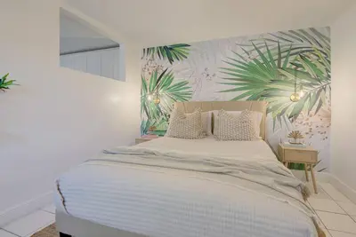 a bedroom with a large bed with a tropical wallpaper at Boho 6, studio Near Air-Cruise Port & Beach in Fort Lauderdale