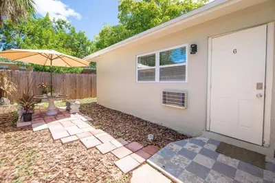 a backyard with a white door and a table and an umbrella at Boho 6, studio Near Air-Cruise Port & Beach in Fort Lauderdale