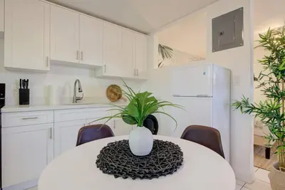 a kitchen with a table with a vase on it at Boho 6, studio Near Air-Cruise Port & Beach in Fort Lauderdale