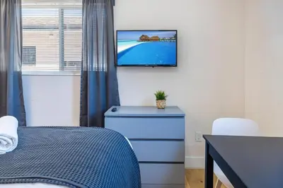 a bedroom with a bed and a tv on the wall at Azure - Mins to Las Olas & Beach in Fort Lauderdale