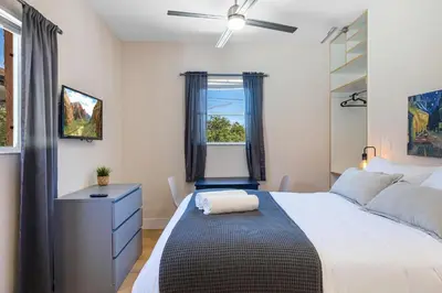 a bedroom with a bed with a desk and a window at Azure - Mins to Las Olas & Beach in Fort Lauderdale