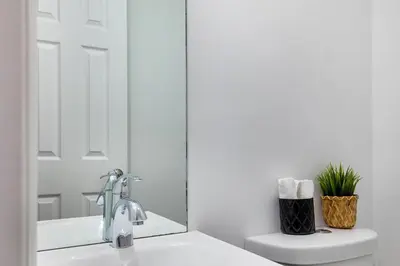 a bathroom with a sink and a toilet and a mirror at Lauderdale Bliss - Mins to Las Olas & Beach in Fort Lauderdale