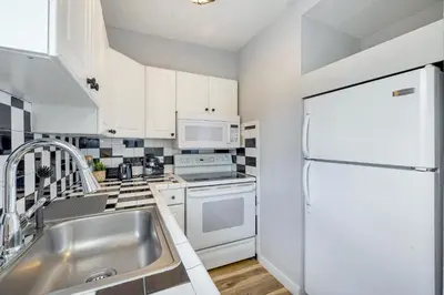 a kitchen with a sink and a white refrigerator at Seascape - Mins to Las Olas & Beach in Fort Lauderdale