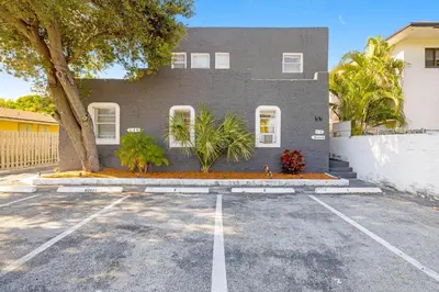 aphalt parking lot in front of a gray house at Seascape - Mins to Las Olas & Beach in Fort Lauderdale