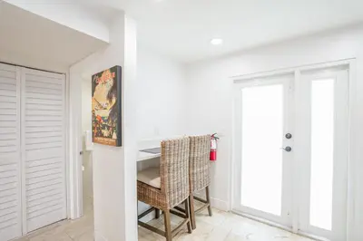 a white room with a table and a chair at Luxury Pool Villa at St. James UNIT E, Pet Friendly in Miami