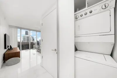 a white kitchen with a stove and a tv at ICON W BRICKELL BY IMD MIAMI Marvelous Ocean View 2BR/2BA in Miami