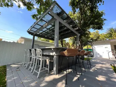 a patio with a table and chairs on a deck at Stylish 3/2 centrally located! in Miami