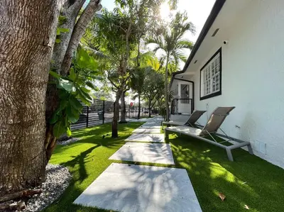 a garden with a bench and trees next to a building at Stylish 3/2 centrally located! in Miami