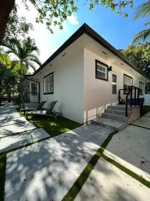 a small white house with two chairs in front of it at Stylish 3/2 centrally located! in Miami