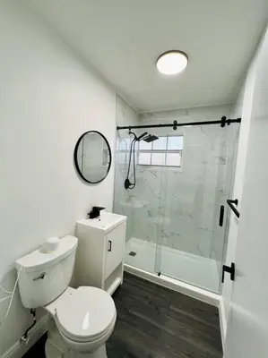 a white bathroom with a toilet and a shower at Stylish 3/2 centrally located! in Miami