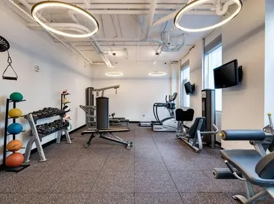 a gym with several tread machines and a flat screen tv at BOULAN HOTEL MIAMI BEACH BY IMD MIAMI 1BR/1BA UNIT in Miami Beach