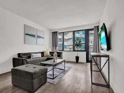 a living room with a couch and a tv at Gorgeous Miami Beach Condo Beach Service 1614 in Miami Beach