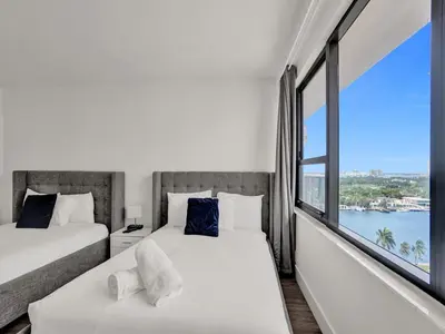 two beds in a room with a large window at Gorgeous Miami Beach Condo Beach Service 1614 in Miami Beach