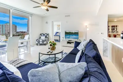 a living room with a blue couch and a table at Tiffany Emerald - Rooftop Pool, Gym, & Walk to Beach in Fort Lauderdale