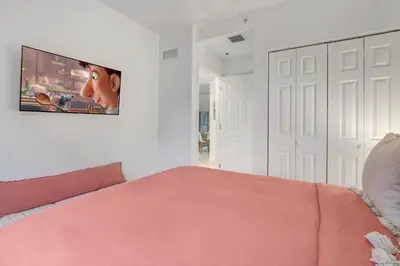a bedroom with a pink bed and a tv on the wall at Wynwood Jumbo - Sleeps 16 & free parking in Miami