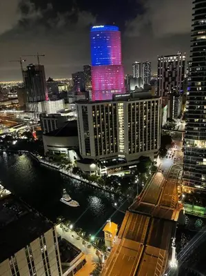 a city skyline at night with a lit up building at Studio at Icon Brickell Luxury Waterfront Building in Miami