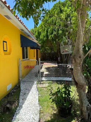 a yellow house with a tree in front of it at Stylish StudioBrickellLittle Havana-ItalianPlaza in Miami