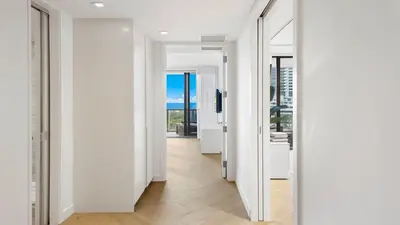 a hallway with white walls and a floor to ceiling mirror at 2B Ocean View Private Residence at South Beach - 804 in Miami Beach
