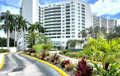 a street in front of a large building with palm trees at Condo, Breathtaking Water views, King Suite, Hilton Property in Fort Lauderdale
