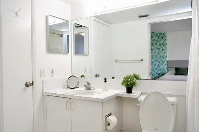 a white bathroom with a sink and a mirror at Charming 2 bedroom 2 bathrooms at aventura in Miami