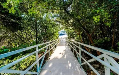 a bridge with trees and a white fence at Charming 2 bedroom 2 bathrooms at aventura in Miami