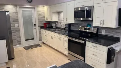 a kitchen with white cabinets and black counter tops at Billy's Resort- Men Only - Solo Hombres in Wilton Manors