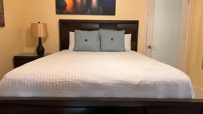 a bedroom with a white bed with a wooden headboard at Billy's Resort- Men Only - Solo Hombres in Wilton Manors
