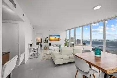 a living room with white furniture and large windows at LOVELY 2 BR W ICON BRICKELL-WATERVIEWS -FREE SPA in Miami