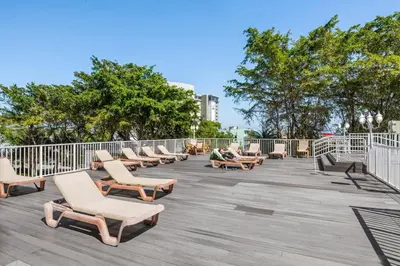 a row of chaise lounge chairs on a deck at Fort Lauderdale Beach Resort by Vacatia in Fort Lauderdale