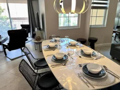 a dining room table with plates and glasses on it at Deluxe Yacht Club Condo Near the Beach in Miami
