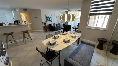 a kitchen and living room with a table and chairs at Deluxe Yacht Club Condo Near the Beach in Miami