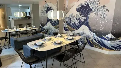 a dining room with tables and a painting of a wave at Deluxe Yacht Club Condo Near the Beach in Miami
