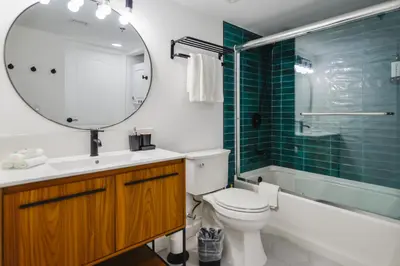 a bathroom with a toilet and a sink and a mirror at Condo with Panoramic City Views in Brickell in Miami