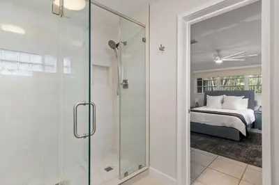 a glass shower in a bedroom with a bed at 3br Oasis near Coral Gable in Miami