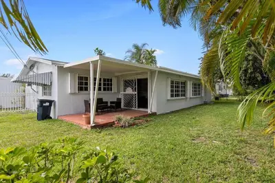 a white house with a porch and a yard at 3br Oasis near Coral Gable in Miami