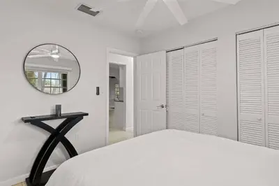a white bedroom with a bed and a mirror at 3br Oasis near Coral Gable in Miami