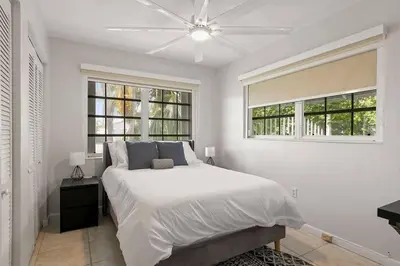a white bedroom with a bed and two windows at 3br Oasis near Coral Gable in Miami