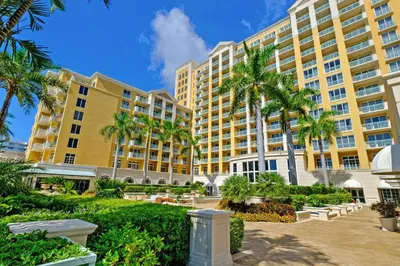 a large yellow building with palm trees in front of it at Stylish Suite to Have a Great Stay! in Miami