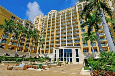 a large yellow building with palm trees in front of it at Stylish Suite to Have a Great Stay! in Miami